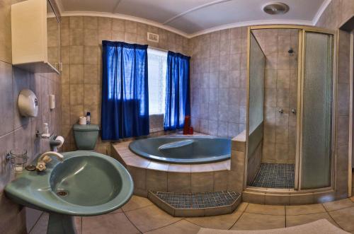 La salle de bains est pourvue d'une baignoire et d'une douche. dans l'établissement La Rochelle Inn, à Richards Bay