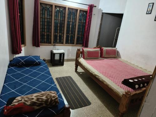 Zimmer mit 2 Betten und einem Fenster in der Unterkunft Bluebell homestay in Chikmagalur
