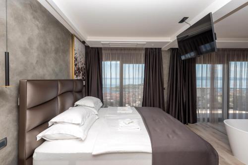 a bedroom with a large bed and a bath tub at Vila Aurelia 2 in Makarska