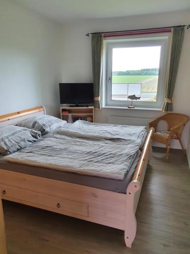 Bett in einem Schlafzimmer mit Fenster in der Unterkunft Ferienwohnung Heike Heitmann in Eystrup
