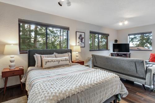 Schlafzimmer mit einem Bett, einem TV und Fenstern in der Unterkunft Osprey Nest in Coupeville