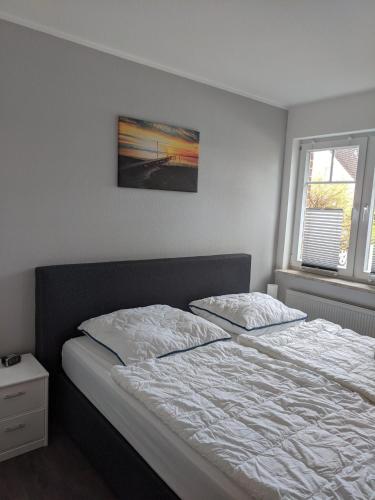 a bedroom with a bed and a picture on the wall at Austernfischer Ferienwohnung in Dangast