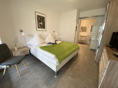 - une chambre avec un lit doté d'une couverture verte dans l'établissement Jadesand Nordsee Park Dangast, à Dangast