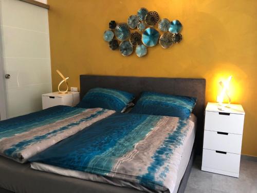 1 dormitorio con 1 cama con sábanas azules y espejo en Meerzeit - Nordsee Park Dangast, en Dangast