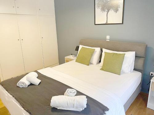 una camera da letto con un grande letto con asciugamani di Check Point - Veikou ad Atene