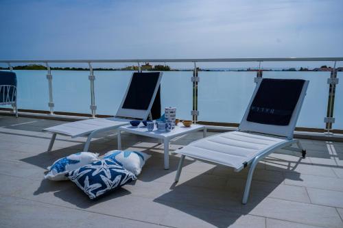two chairs and a table on top of a roof at NSM Blumarine Attico con servizio spiaggia in Campomarino