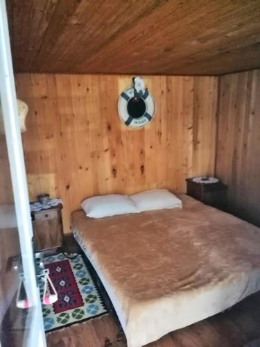 a bedroom with a bed in a wooden room at Splav Ljubavno Ostrvo in Čerević