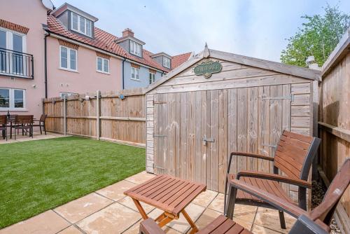 a backyard with a wooden fence and two chairs at Rest Ashored, Aldeburgh in Aldeburgh