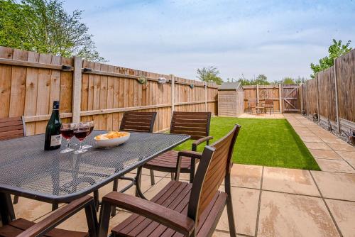 a patio with a table and chairs with wine glasses at Rest Ashored, Aldeburgh in Aldeburgh