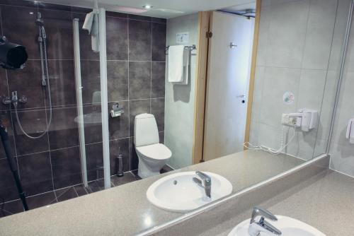 a bathroom with a sink and a shower and a toilet at Park Hotel Latgola in Daugavpils