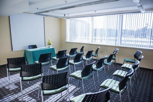a room with chairs and a table and a screen at Park Hotel Latgola in Daugavpils