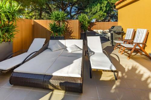 a bed and two chairs on a patio at Penthouse Duplex Rooftop Jacuzzi 4 Rooms 6 beds 8 Persons in Cascais