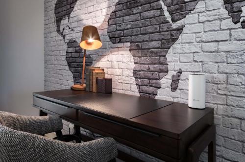 a desk with a lamp and a brick wall at Penthouse Duplex Rooftop Jacuzzi 4 Rooms 6 beds 8 Persons in Cascais