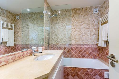 a bathroom with a sink and a shower and a tub at Penthouse Duplex Rooftop Jacuzzi 4 Rooms 6 beds 8 Persons in Cascais