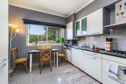 a kitchen with white cabinets and a table and chairs at Penthouse Duplex Rooftop Jacuzzi 4 Rooms 6 beds 8 Persons in Cascais