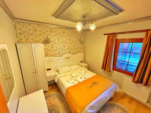 een kleine slaapkamer met een bed en een raam bij Kuzey Suite Otel in Uzungol