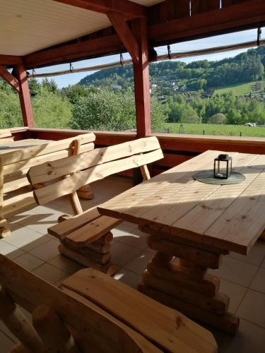 a wooden table and benches on a porch at Pensjonat na Wzgórzu in Solina
