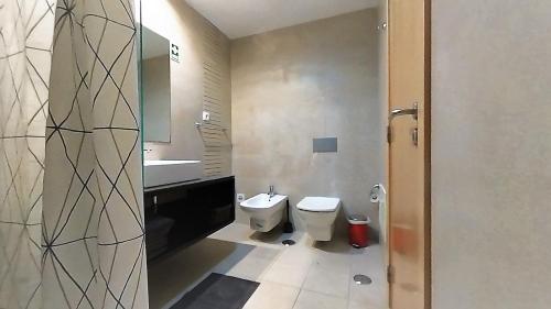y baño con aseo y lavamanos. en Apartamentos Turisticos Rocha Tower 13C, en Portimão