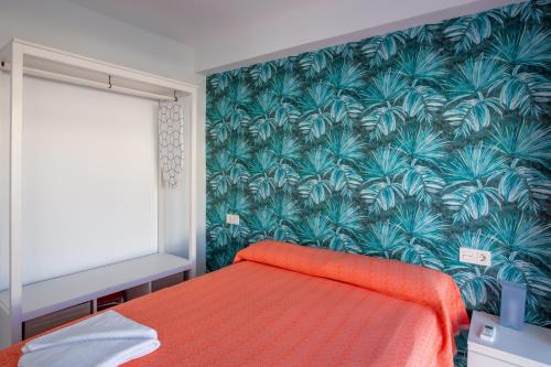 sypialnia z łóżkiem z tropikalną tapetą w obiekcie Mariam Mojácar Apartment w mieście Mojácar