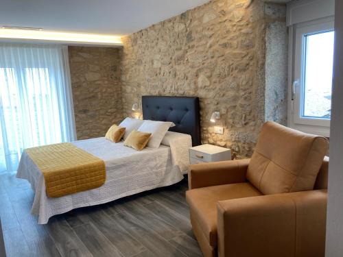 1 dormitorio con 1 cama, 1 sofá y 1 silla en Apartamentos Currás en Touriñán, en Touriñán