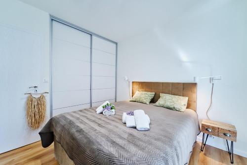 a bedroom with a large bed with towels on it at Blanca Apartamenty Polanica-Zdrój, Polanica Residence in Polanica-Zdrój
