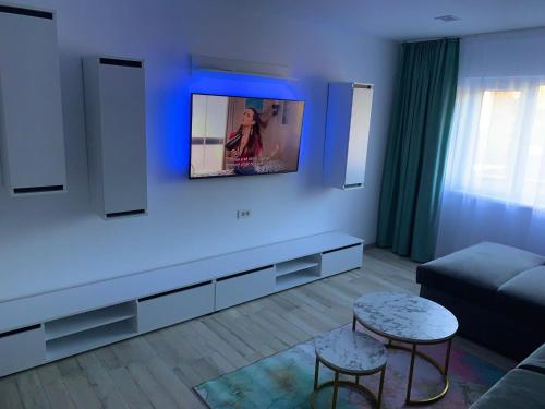 sala de estar con sofá y TV en la pared en Apartament Infinity Petroșani, en Petroşani