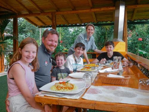 a group of people sitting at a table with food at Casa de Vista Alta in Mindo