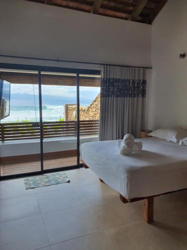 a bedroom with a bed and a view of the ocean at Moorea Lodge Bungalow in Temae