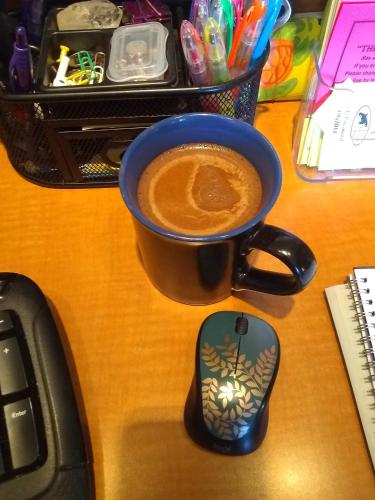 a cup of coffee sitting on a desk next to a keyboard at The Orca Inn in Friday Harbor