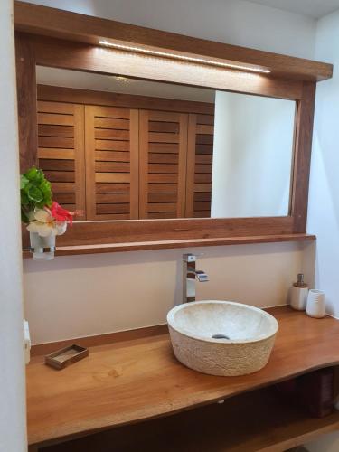 a bathroom with a sink and a mirror at Moorea Lodge Bungalow in Temae