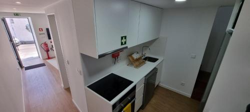 a kitchen with white cabinets and a counter top at Sea House - Santa Clara in Ponta Delgada