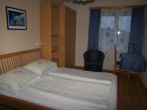 Schlafzimmer mit einem Bett, einem Tisch und einem Fenster in der Unterkunft Gasthof-Pension Weninger in Paldau