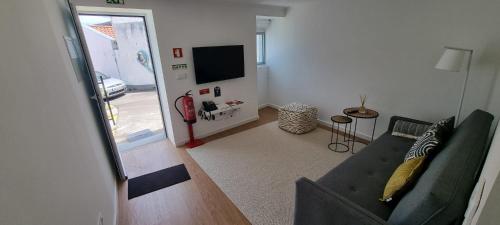 a living room with a couch and a television at Sea House - Santa Clara in Ponta Delgada