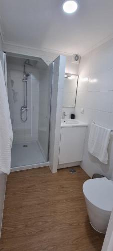 a white bathroom with a shower and a toilet at Sea House - Santa Clara in Ponta Delgada