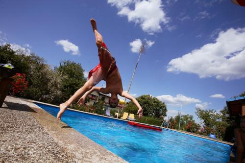 a man doing a handstand next to a swimming pool at Gasthof-Pension Weninger in Paldau