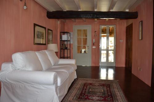 sala de estar con sofá blanco y alfombra en B&B Il Torrazzo, en Crema