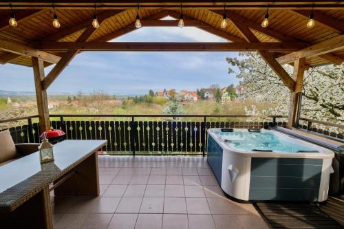 a hot tub on the patio of a house at Bogdányi Kisház in Dunabogdány