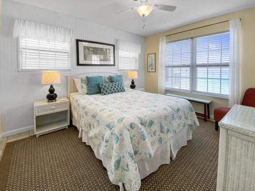 a bedroom with a bed and two windows at Highview Sunseekers 7 Condo in Santa Rosa Beach