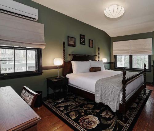 a bedroom with a large bed and two windows at The Constance by The Lenox Collection in Lenox