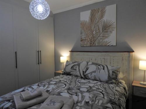 a bedroom with a bed and a pendant light at Locust Retreat in Marloth Park in Marloth Park
