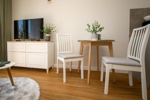 a living room with two chairs and a tv at Apartament Willa Lniana in Sulechów
