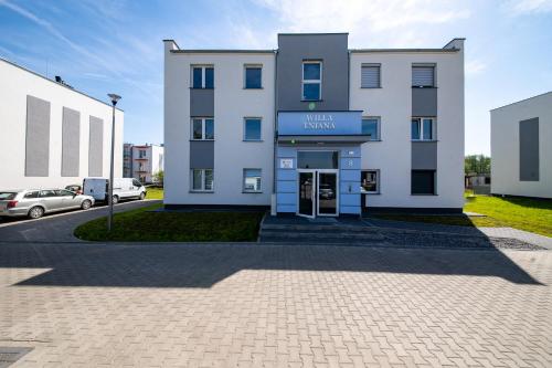 a large white building with a parking lot at Apartament Willa Lniana in Sulechów