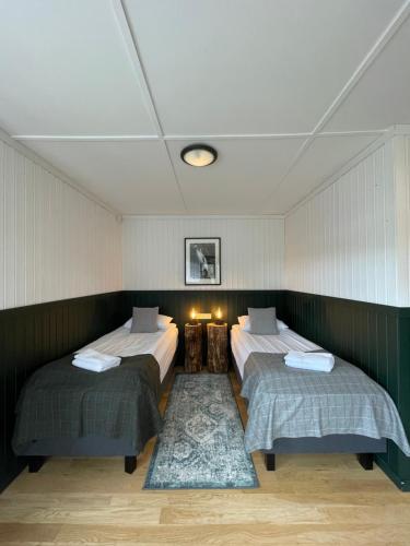 a room with two beds and two tables in it at Aurora Lodge Hotel in Hvolsvöllur