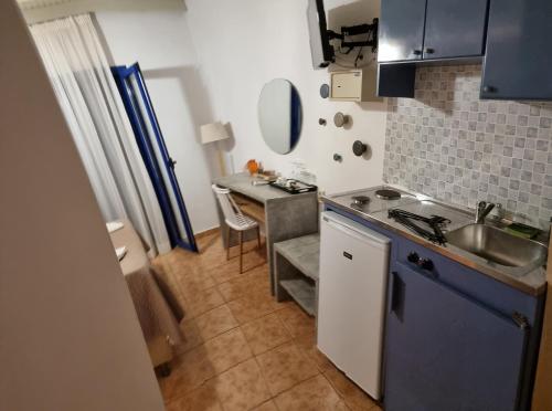 a small kitchen with a sink and a table at Loutro Holidays in Loutro
