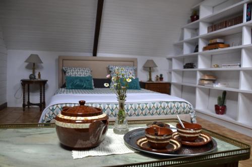 - une chambre avec un lit et une table avec de la vaisselle dans l'établissement Isis et Horus ressourcement, à Scaër