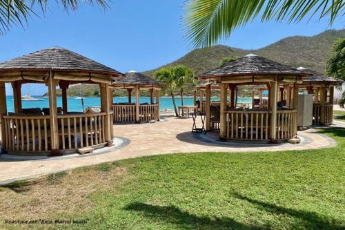 a group of gazebos with the ocean in the background at Kaffa50 - Plage & 3Piscines - Anse Marcel in Anse Marcel 