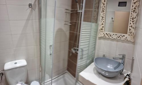 a bathroom with a shower with a sink and a mirror at Loutro Holidays in Loutro
