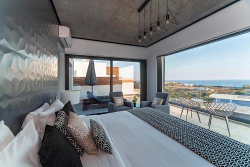 a bedroom with a large bed and a large window at amara luxury villas in Lachania