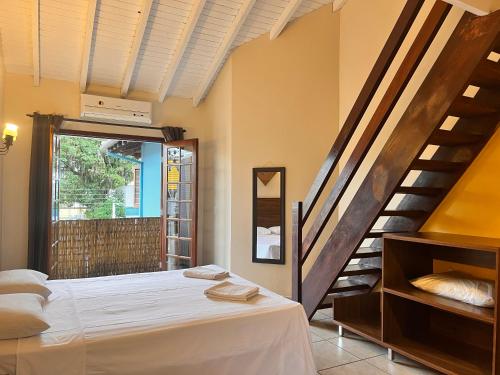 ein Schlafzimmer mit einem Bett und einer Treppe in der Unterkunft Delphin Apartamento 8 in Ilhabela