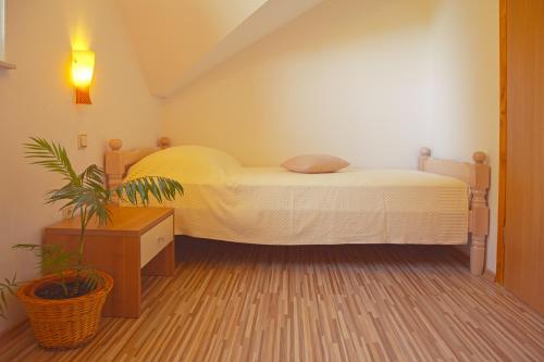 a bedroom with a bed and a potted plant at Apartment Ivan in Smoljanac